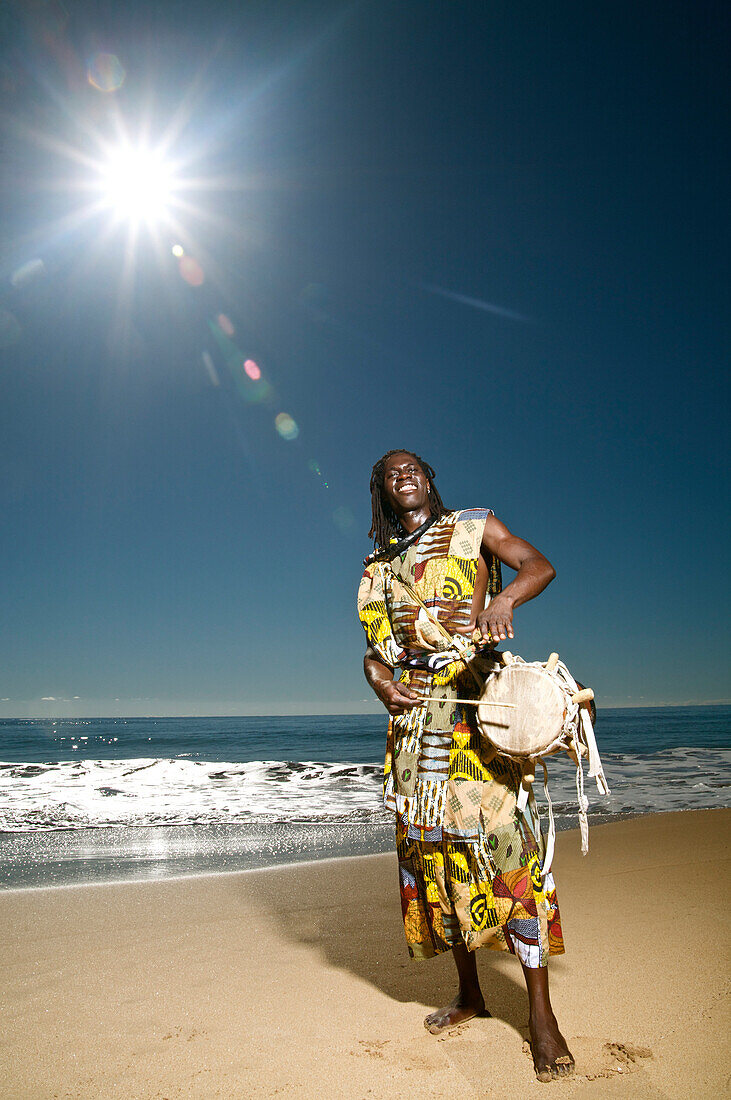 Hawaii, Kauai, Kealia Beach, African dancer on shore with drum.