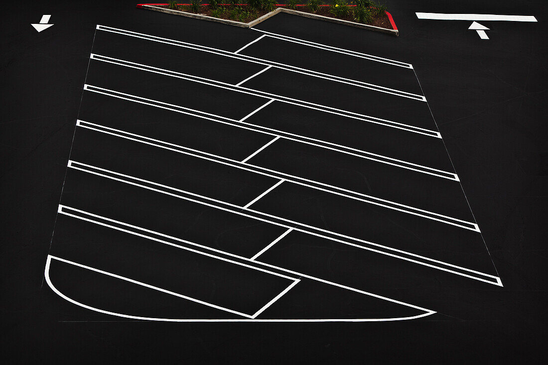 A car park, indoors parking lot, with a freshly resurfaced, black top surface, with newly painted white lines marking the parking bays. View from above., Los Angeles, California, USA. Parking Lot