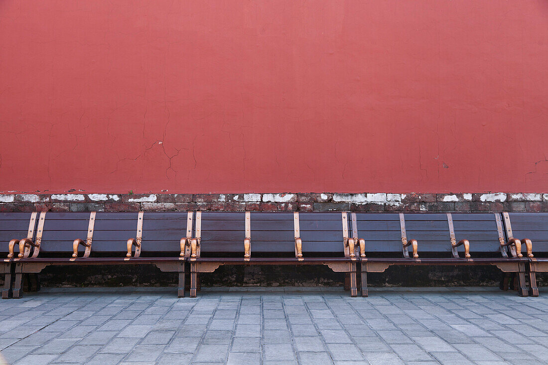 Benches run along a wall inside the Forbidden City in Beijing, China., Beijing, China. Forbidden City seating