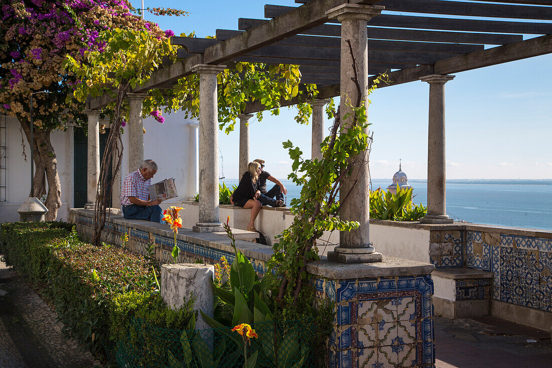 Menschen am Aussichtspunkt Miradouro Jardim de Julio de Catilho in der Alfama, Lissabon, Portugal