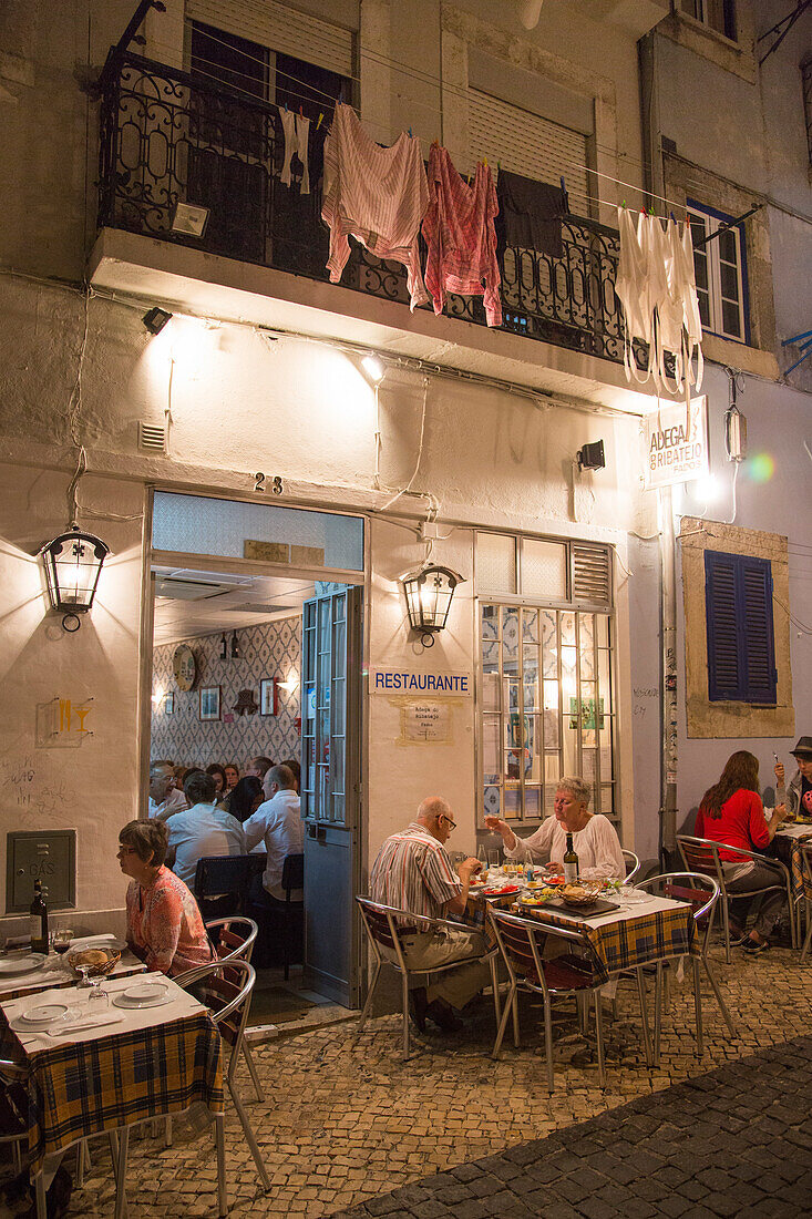 Menschen sitzen vor dem Adega do Ribatejo Restaurant in der Bairro Alto Altstadt und genießen ihr Abendessen, Lissabon, Portugal