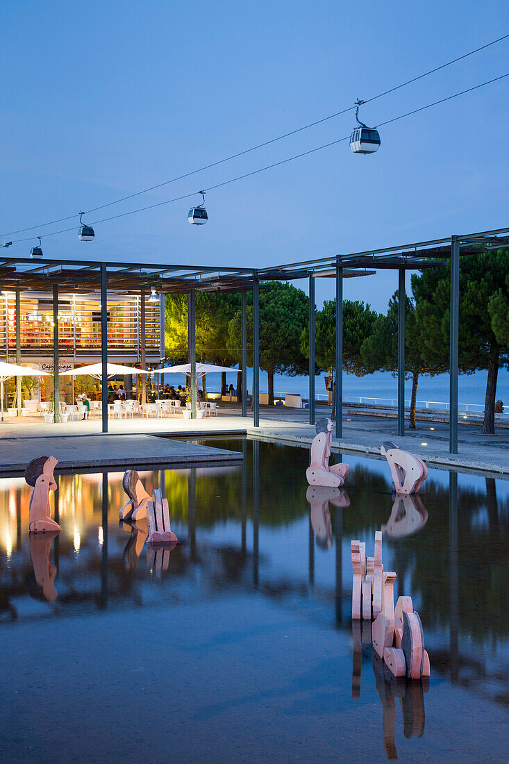 Sculptures in the water basin at Parque das Nacoes, Park of Nations, with Teleferico Lisboa, Lisboa Cable Car, at dusk, Lisbon, Lisboa, Portugal