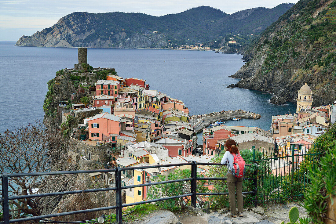 Woman looking towards Vernazza, Mediterranean sea in the background, Vernazza, Cinque Terre, National Park Cinque Terre, UNESCO World Heritage Site Cinque Terre, Liguria, Italy