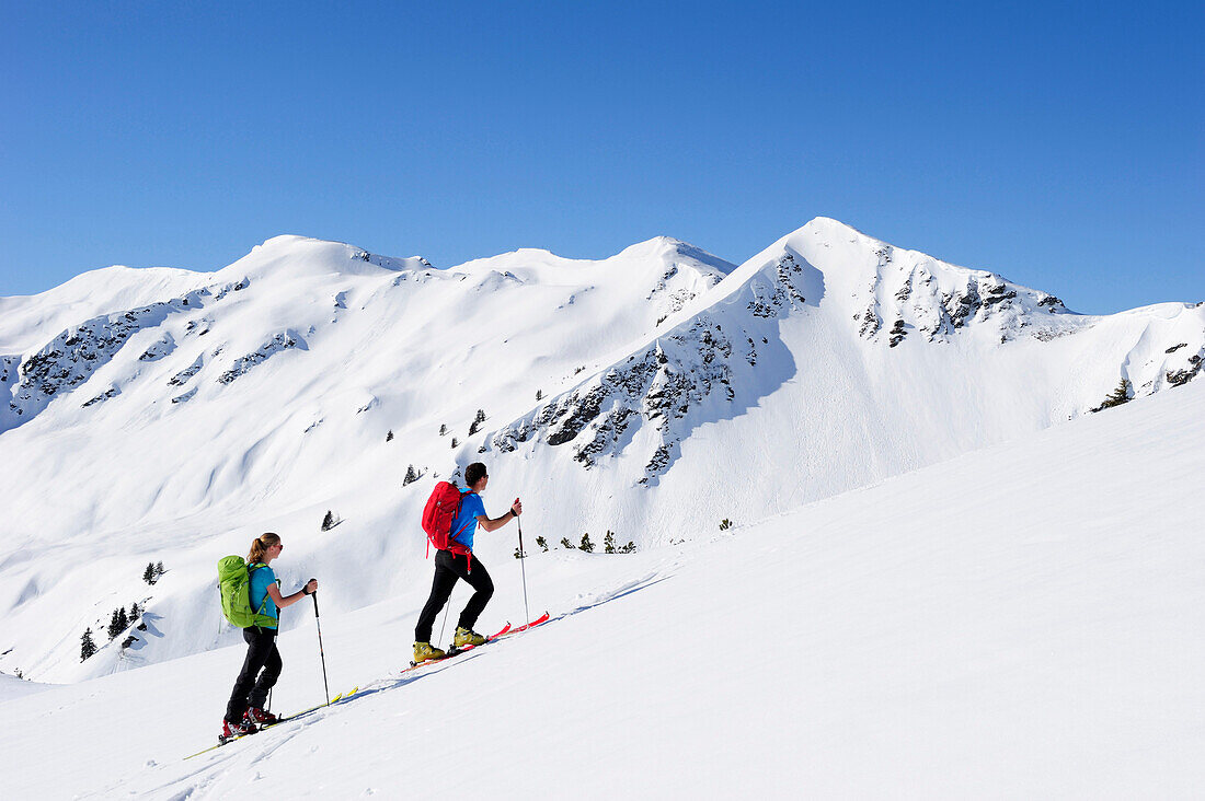 Zwei Skitourengeher beim Aufstieg zum Brechhorn, Großer Rettenstein im Hintergrund, Kitzbüheler Alpen, Tirol, Österreich