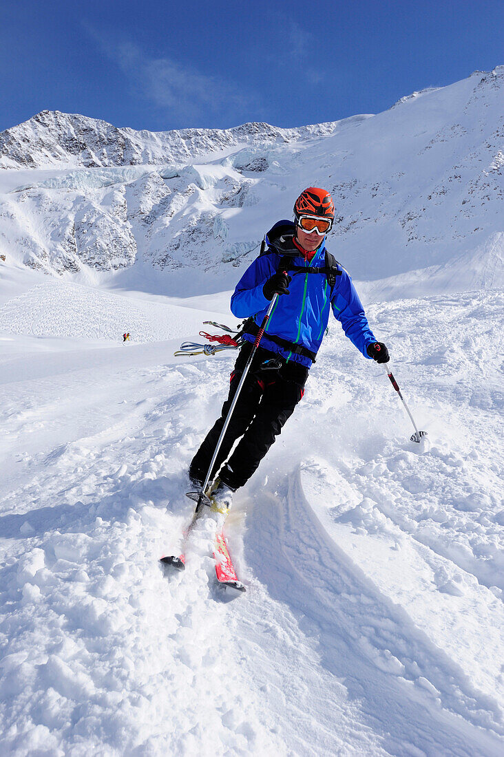 Young man downhill skiing from Wildspitze on glacier, Oetztal Alps, Tyrol, Austria