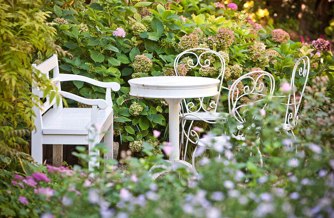 Sitzbank mit einem Tisch und Stühle, eine ruhige Ecke im Garten, Wien, Österreich