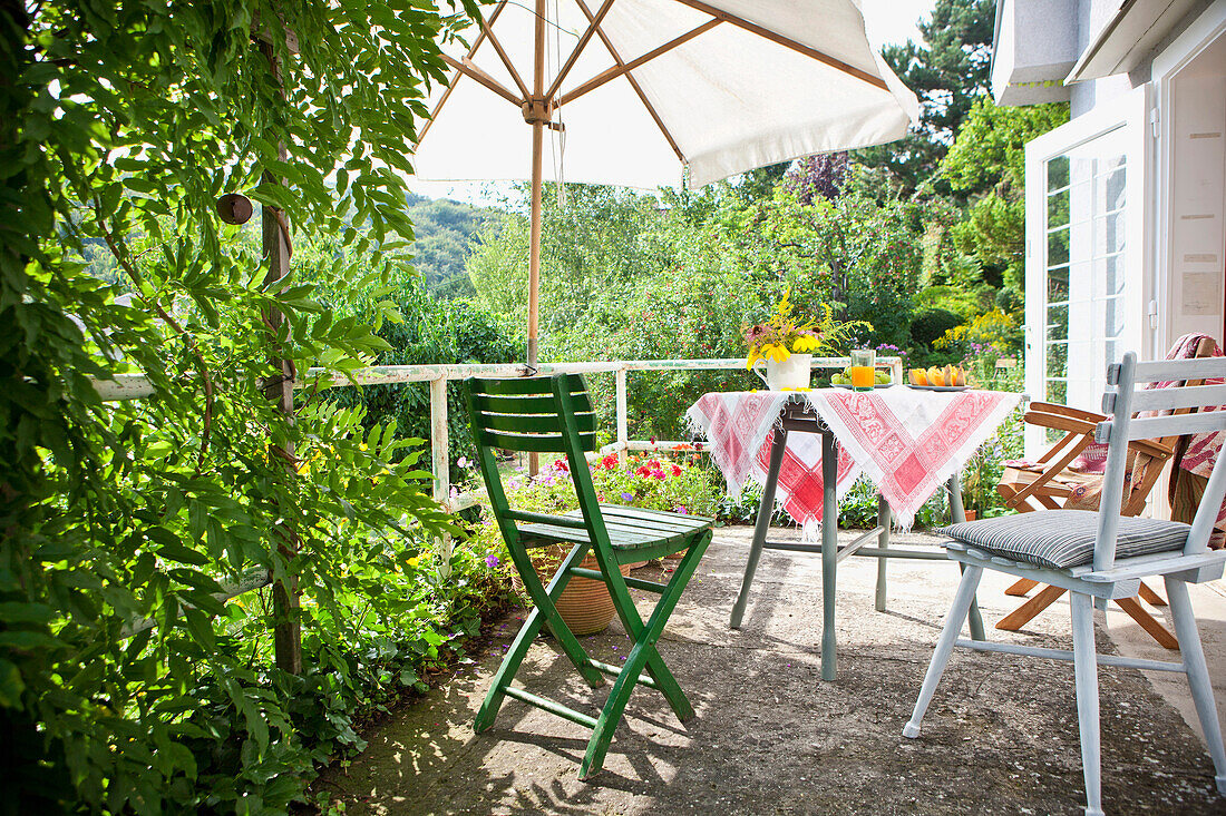 Tisch mit Frühstück, Terrasse in einem Garten, Sonnenschirm, Wien, Österreich