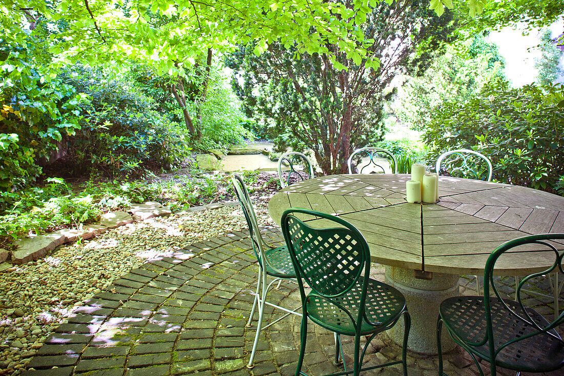 Candles on the table with chairs, formal garden in summer, atrium, Vienna, Austria