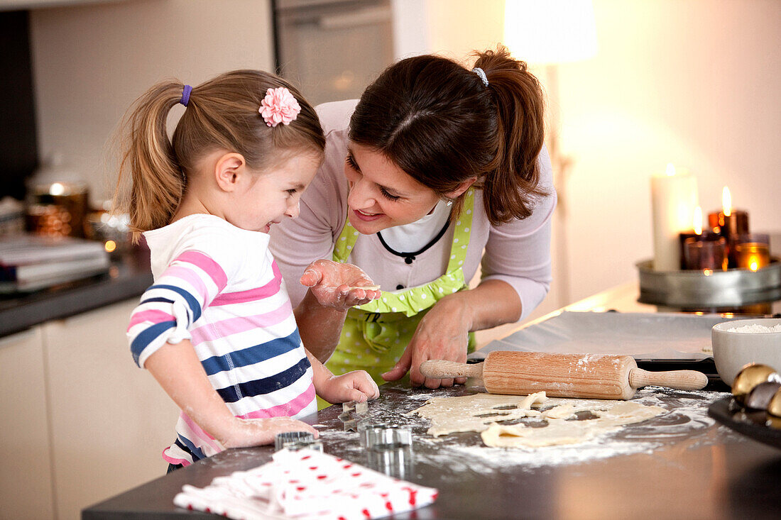 Mother and daughter (4 years) baking cookies