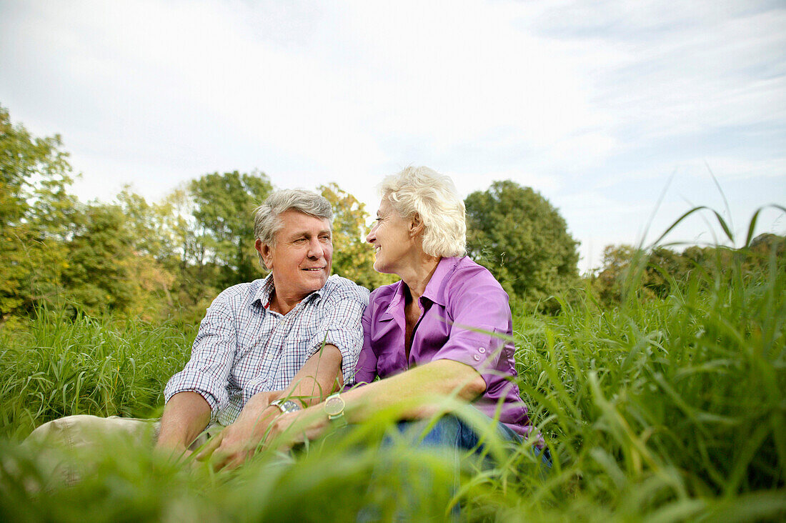 Senior couple sitting on grass, Vienna, Austria