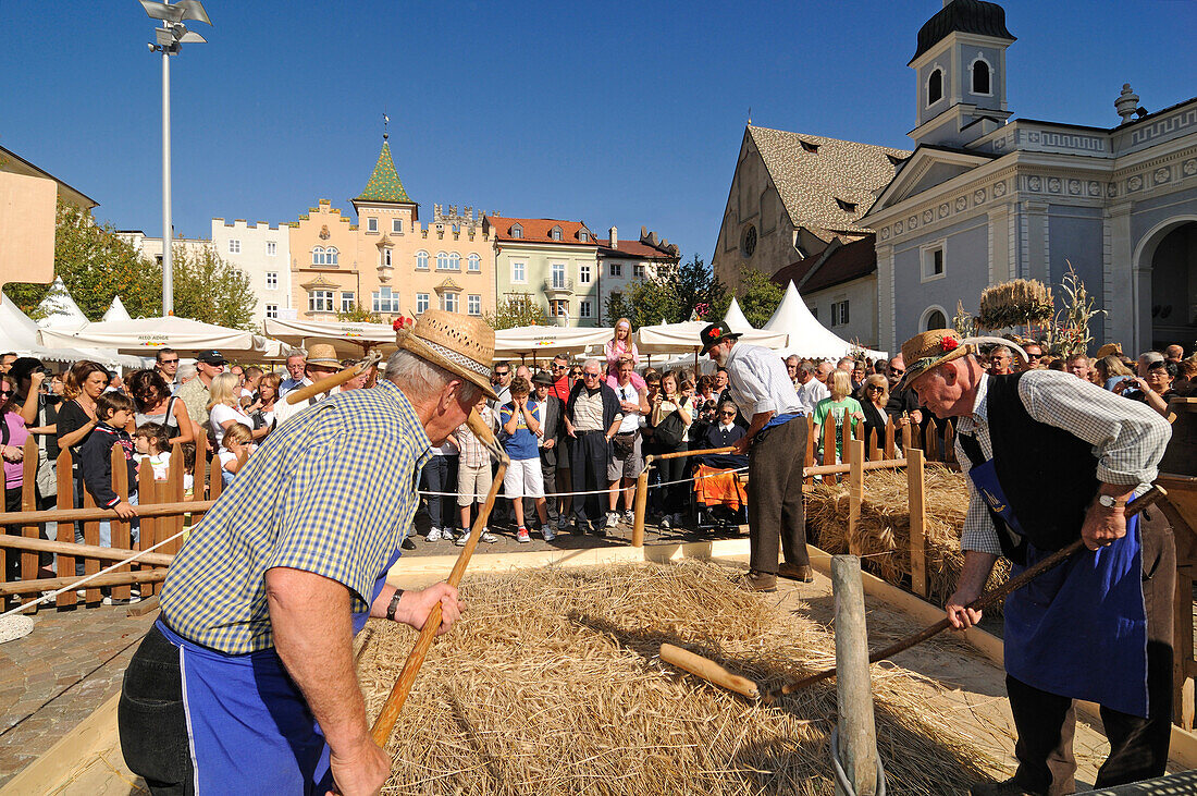 Drei Männer beim Dreschen, Erntefest, Domplatz, Brixen, Suedtirol, Italien