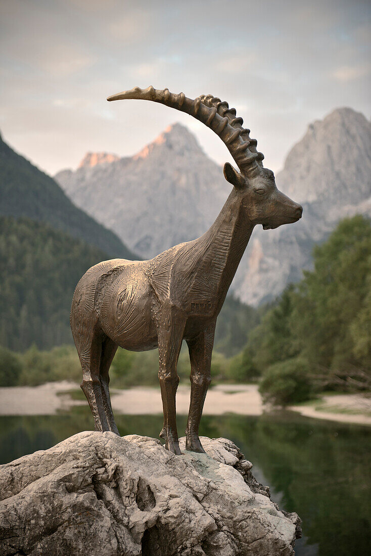 Capricorn Zlatorog at Jasna Lake with mountains in backdrop, Kranjska Gora, Julian Alps, Gorenjska, Slovenia