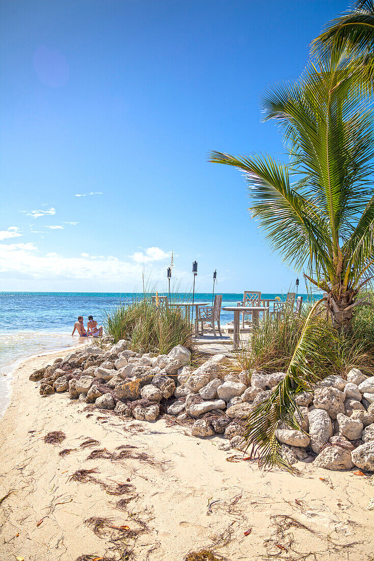 Beach with tourist couple, Little Palm Island Resort, Florida Keys, USA