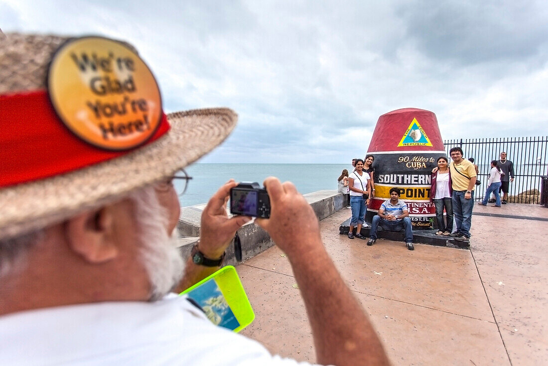 Lokaler Touristenführer mit Touristen am Denkmal Southernmost Point, südlichster Punkt Festland USA, Key West, Florida, USA