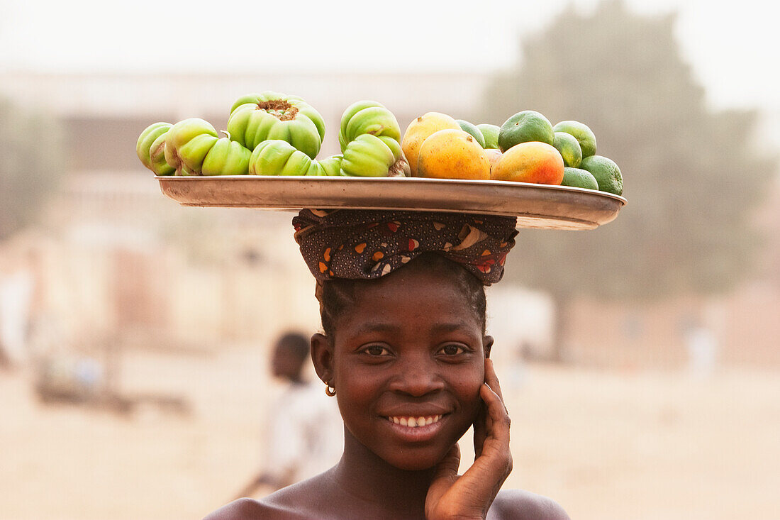Girl carrying fruits on her head, Segou, Mali