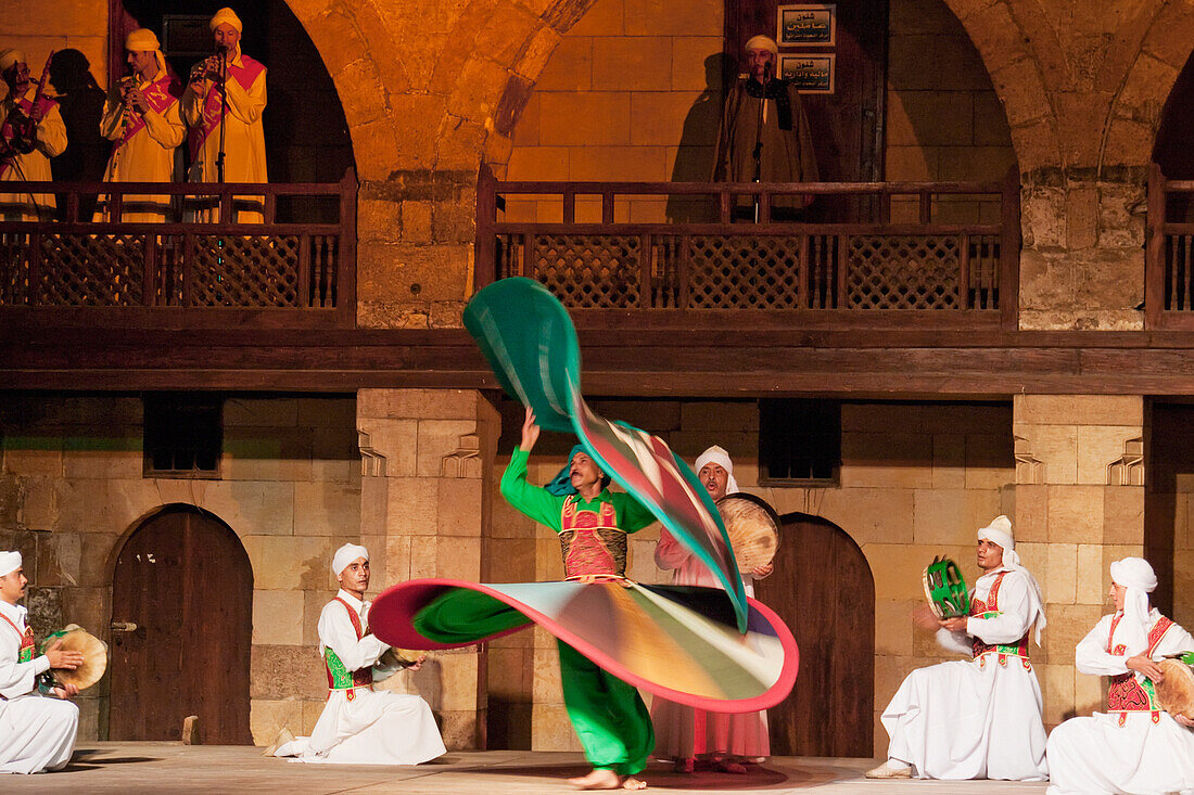 Whirling dervish performing a Sufi dance at the Al-Ghouri Mausoleum at night, Cairo, Al Qahirah, Egypt