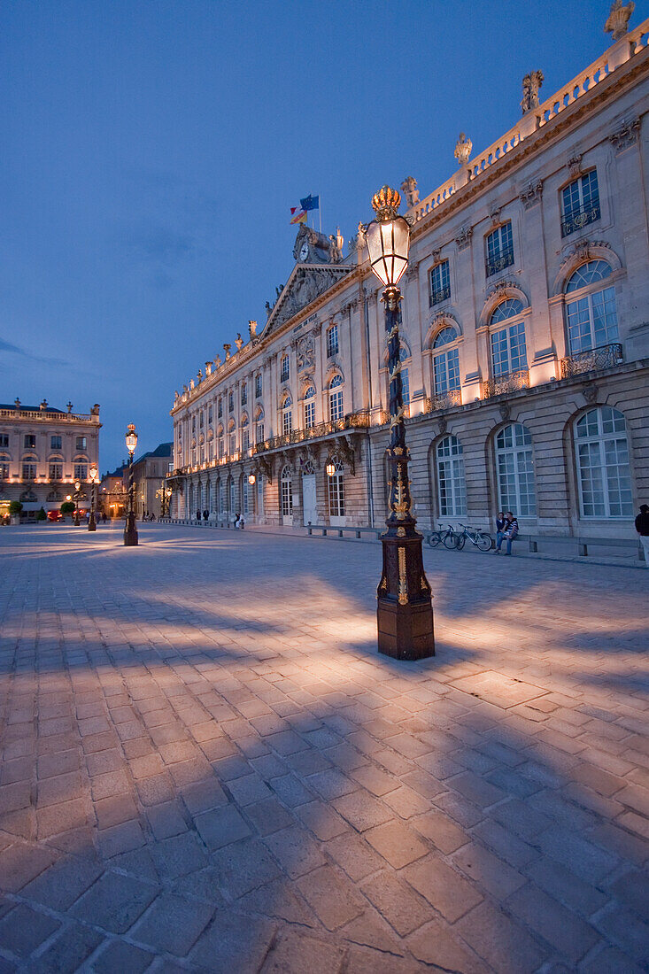 Gilded wrought iron lantern, created by Jean Lamou in front of the Hotel de Ville (City Hall) on Place Stanislas at night, Nancy, France
