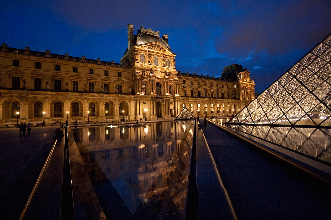 Louvre Pyramid by the architect I.M. Pei and Denon Wing of the Louvre Museum at night, Paris, France