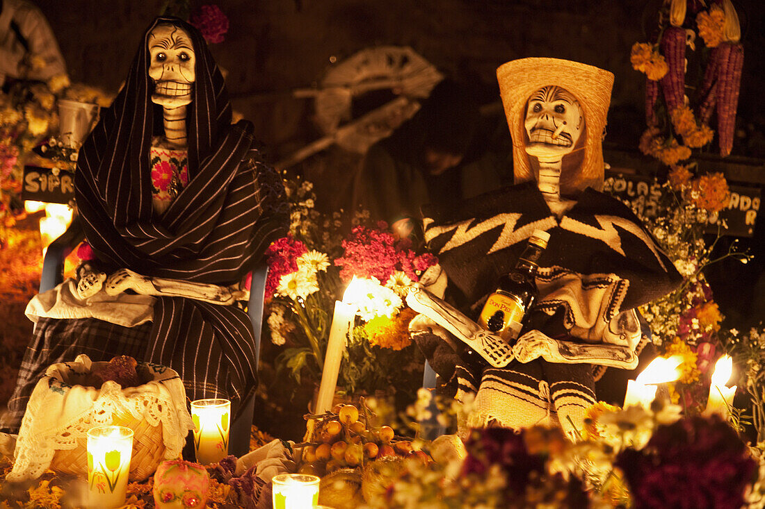Skeletons (calacas) decorate this grave during the celebration of DÃ­a de los Muertos, the Day of the Dead at the TzurumÃºtaro cemetery. People decorate the graves of their loved ones with offerings of flowers, particularly marigolds (cempoalxÃ³chitl or z