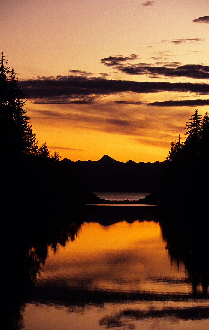Alaska, Juneau, Petersen Creek, Mountains, trees and sunset reflections.