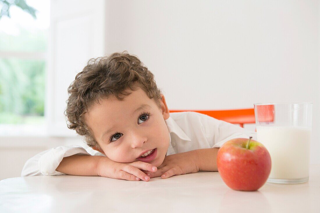 Vierjähriger Junge mit Milch und Obst zum Schnabelfrühstück