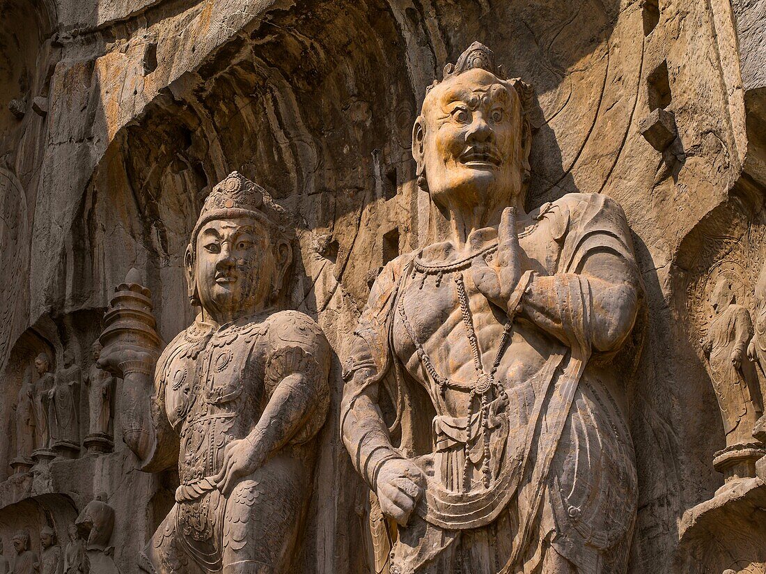 Statue of Vaisravana and warrior  North wall of Fengxiansi Cave  The grottoes were started around the year 493 when Emperor Xiaowen of the Northern Wei Dynasty 386-534 moved the capital to Luoyang and were continuously built during the 400 years until the