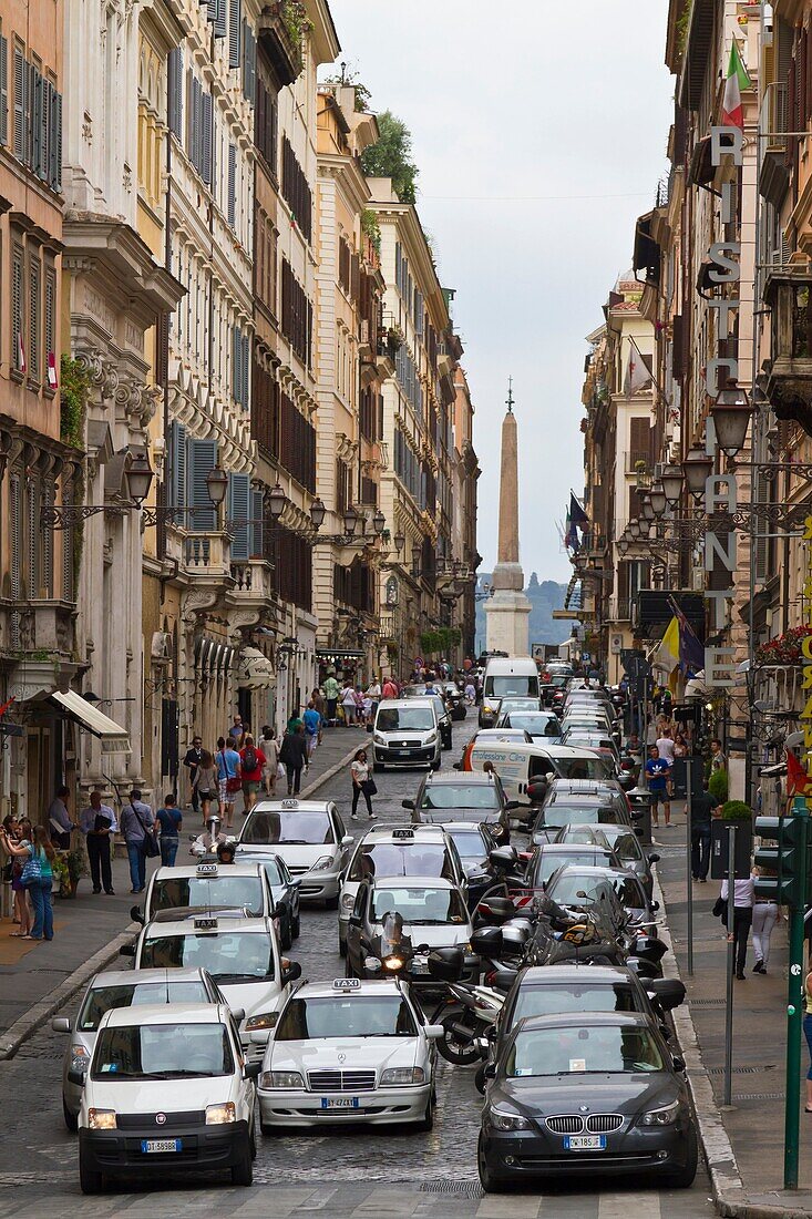 A narrow street with cars in central Rome, Italy