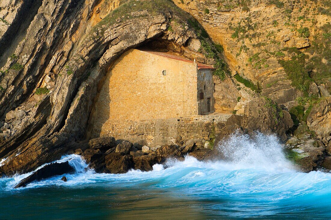 The small Santa Justa Chapel, embedded into the cliff  Santa Justa beach, Ubiarco village  Santillana del Mar  Cantabria  Spain