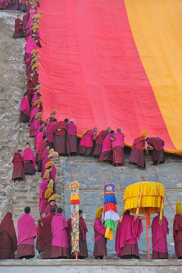 China, Gansu, Amdo, Xiahe, Monastery of Labrang Labuleng Si, Losar New Year festival, Monks unfurling the giant Thangka