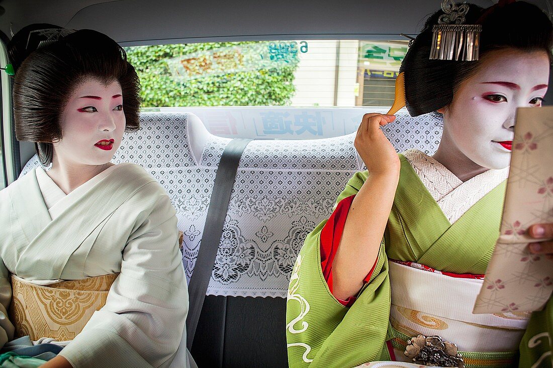 Fukuyu,geisha and Fukukimi,´maiko´ geisha apprenticein taxi going to work Geisha´s distric of Miyagawacho Kyoto  Kansai, Japan