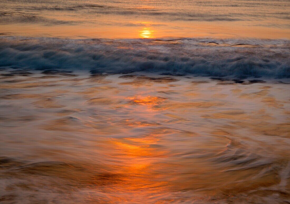 Waves breaking near shore at sunrise