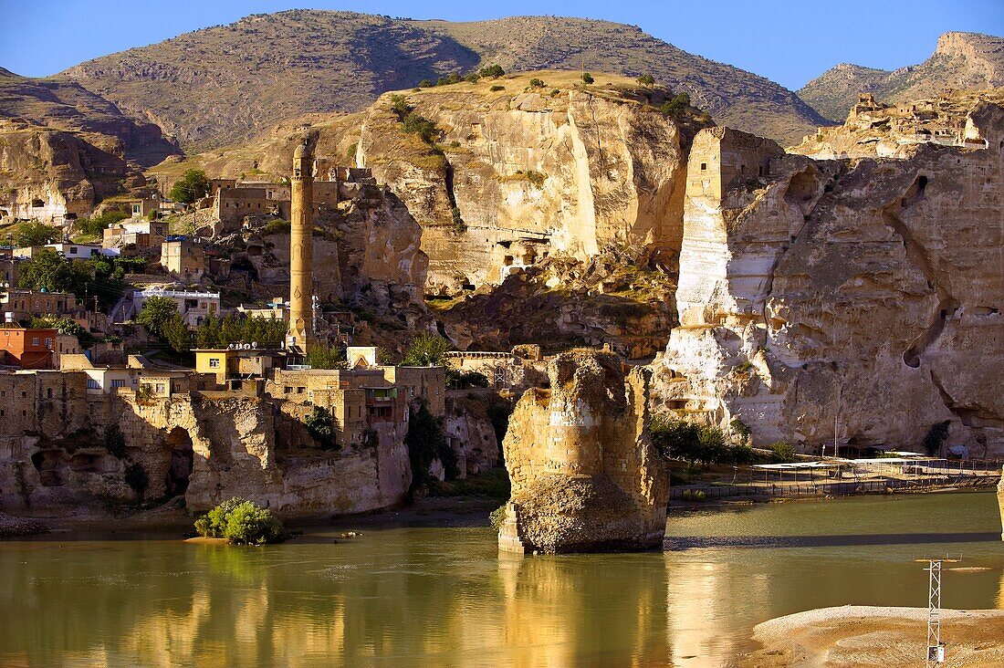 Remains of medieval Artukid Old Tigris Bridge â Built in 1116 by Artukid Fahrettin Karaaslan, the biggest in Anatolia at the time, with the old town Hasankeyf and its ruins on the cliffs abover the river Tigris  The minaret is of the El Rizk Mosque built.
