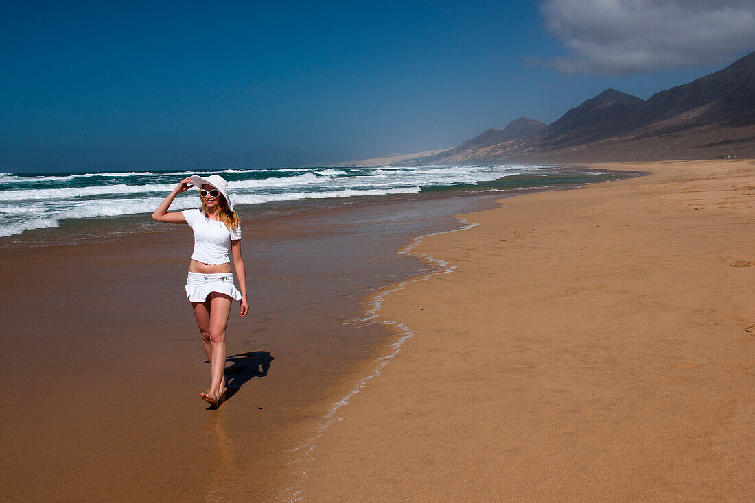 Junge Frau geht am Strand entlang, Naturpark, Jandia, Fuerteventura, Kanarische Inseln, Spanien, Europa