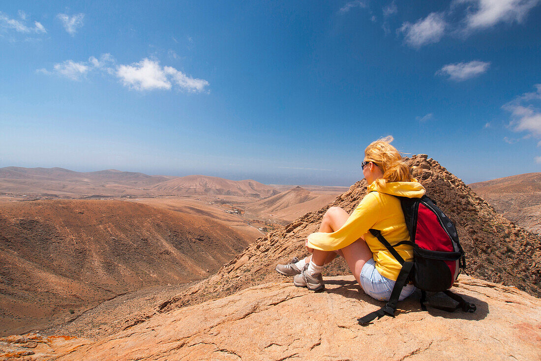 Woman sitting on the top of a mountain, view point, Pajara, Betancuria, Fuerteventura, Canary Islands, Spain, Europe