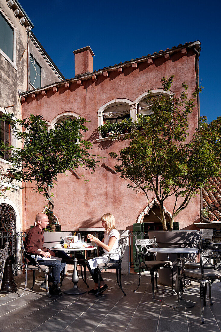 Guests having breakfast at a hotel rooftop terrace, Venice, Veneto, Italy