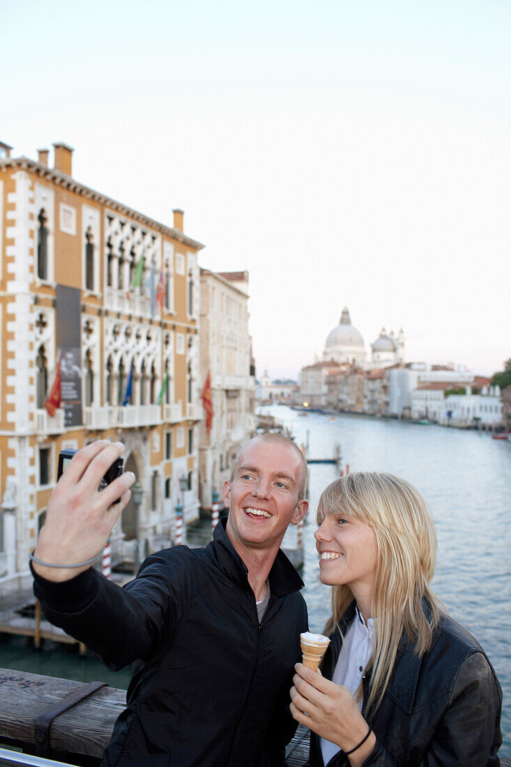 Couple taking pictures of themselvs on bridge Ponte dell Accademia at the Grand Canal, Venice, Veneto, Italy