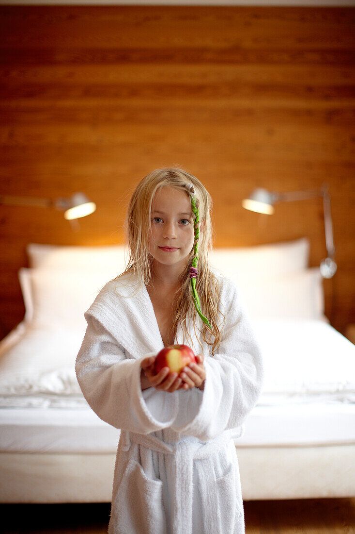 Girl in a double room at Hotel Haus Hirt, holding an apple, Bad Gastein, St. Johann im Pongau, Salzburg, Austria