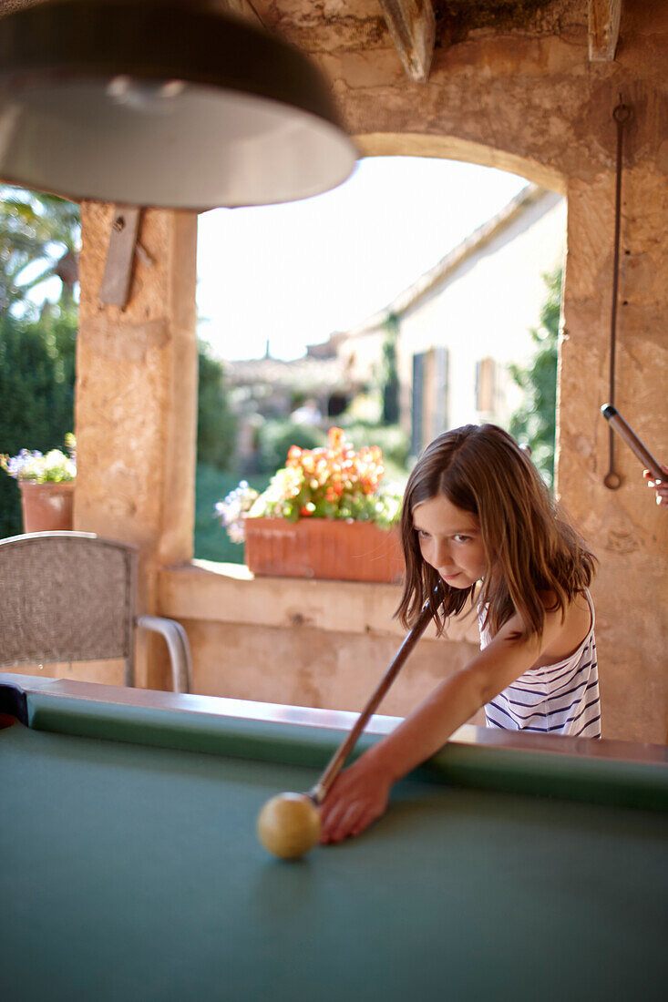 Mädchen spielt Billard auf überdachter Terrasse, Algaida, Mallorca, Balearische Inseln, Spanien