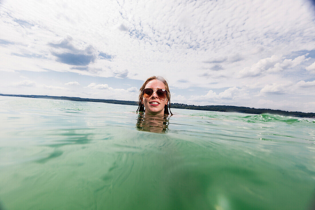 Young woman bathing in lake Starnberg, Bavaria, Germany