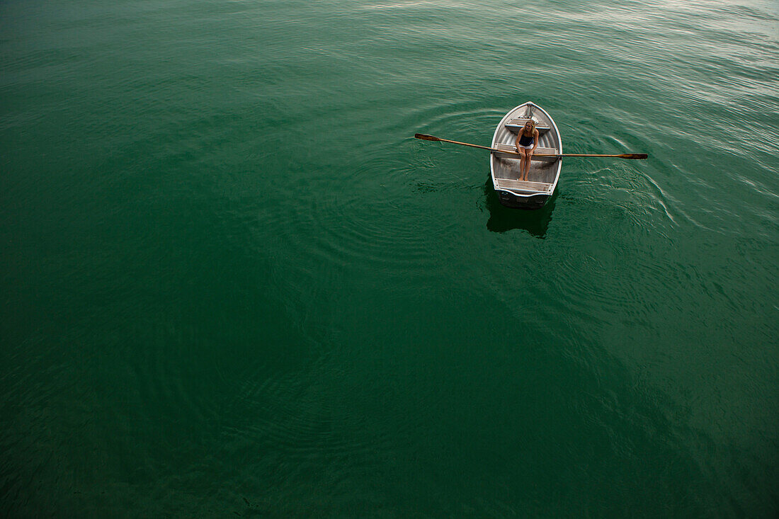 Young woman in a rowboat on lake Starnberg, Bavaria, Germany