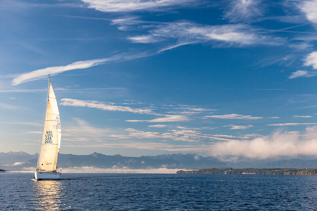 Sailing boat on Lake Starnberg, the Alps in background, Bavaria, Germany