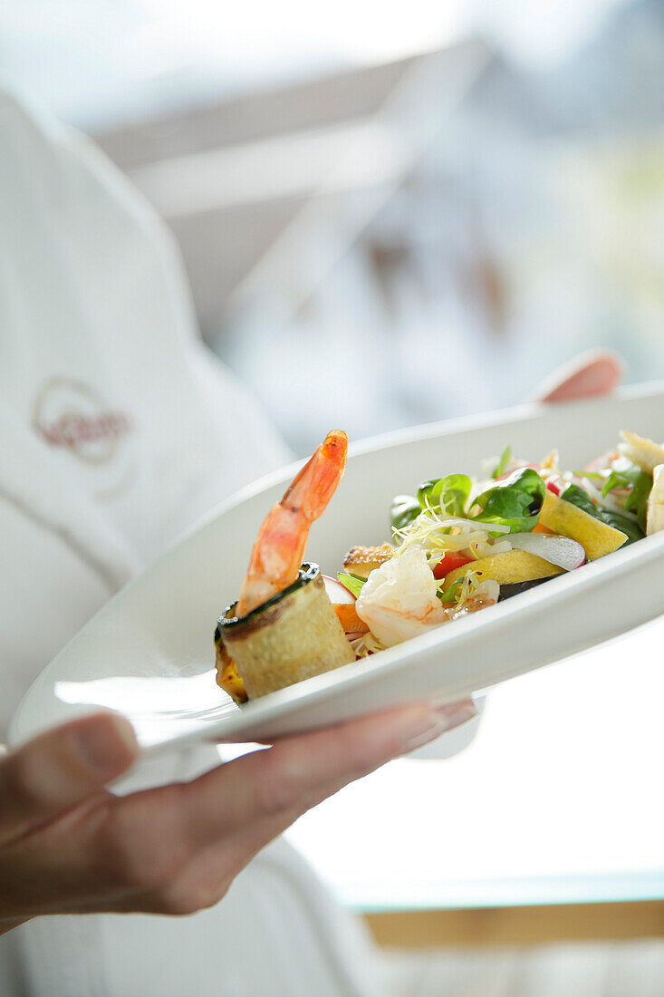 Hotel guest holding a plate of salad, Tannheim, Tannheim Valley, Tyrol, Austria