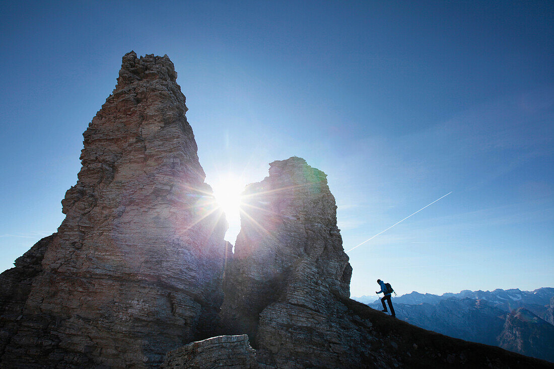 Bergwanderer steigt zu einem Felsen auf, Hochiss, Rofangebirge, Tirol, Österreich