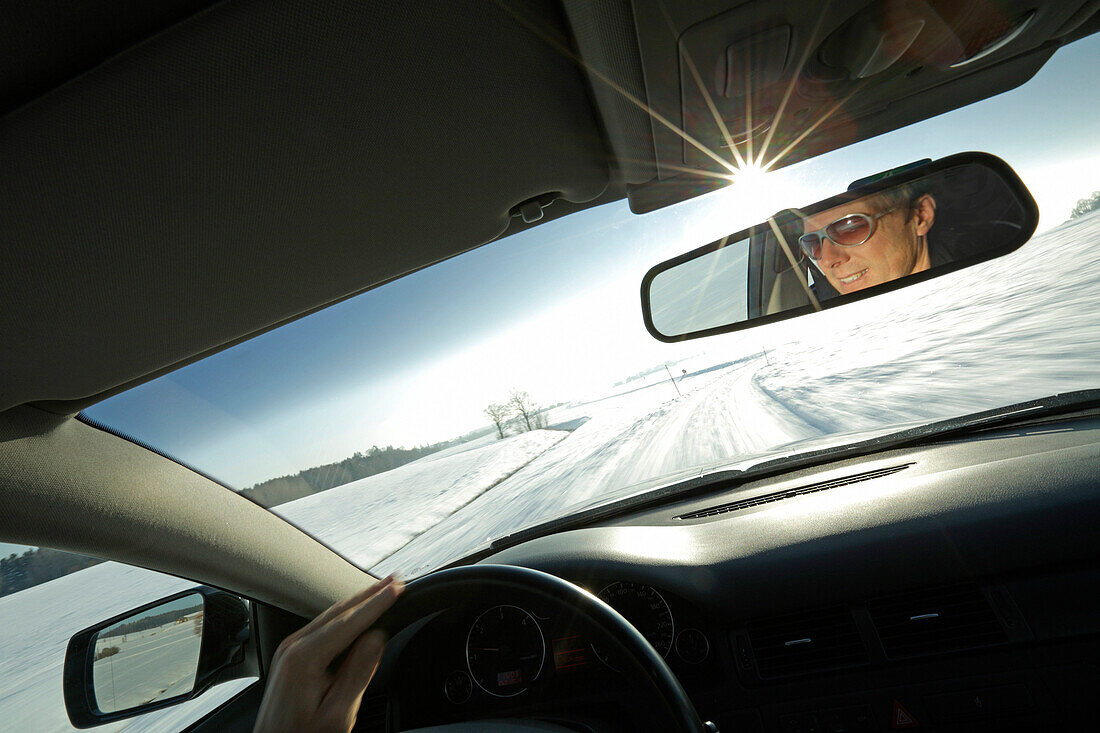 Mann fährt über schneebedeckte Straße, Bayern, Deutschland