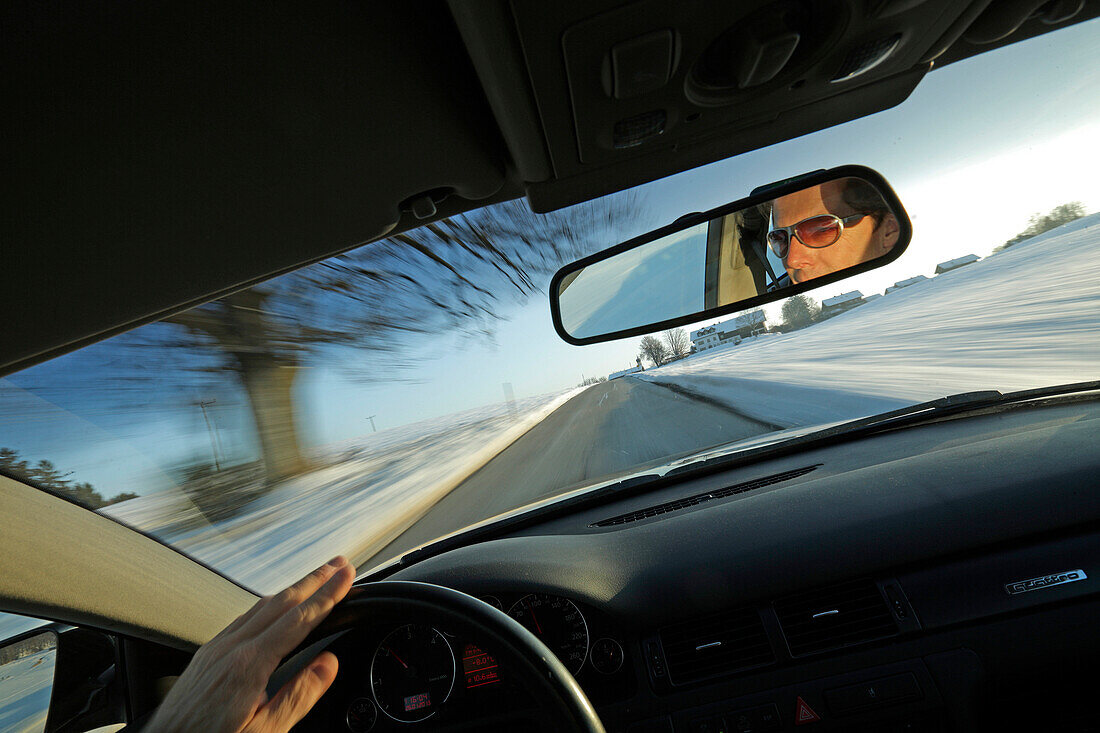 Mann fährt über eine Landstraße im Winter, Bayern, Deutschland