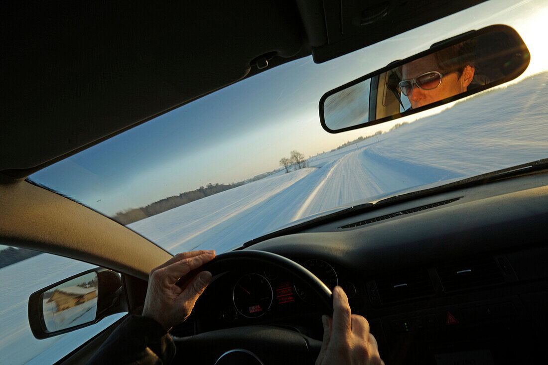 Mann fährt über schneebedeckte Straße, Bayern, Deutschland