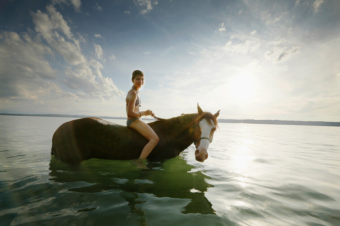 Mädchen auf einem Pferd im Starnberger See, Bayern, Deutschland