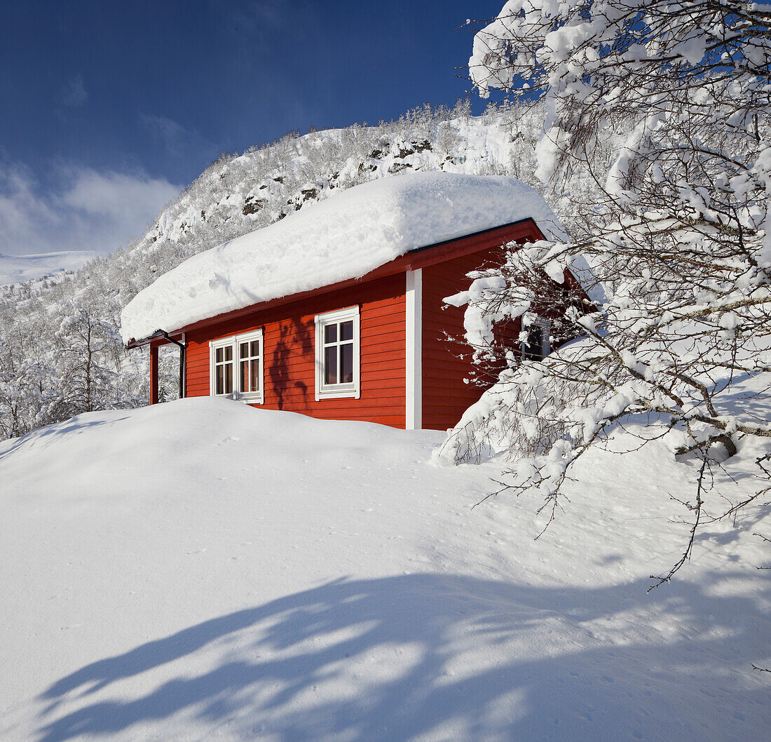 Verschneite Hütte in Winterlandschaft, Myrkdalen, Hordaland, Norwegen