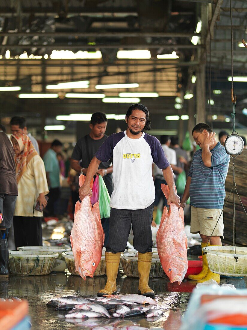 FIshermen and workers at an open air fish market in Johor, Malaysia