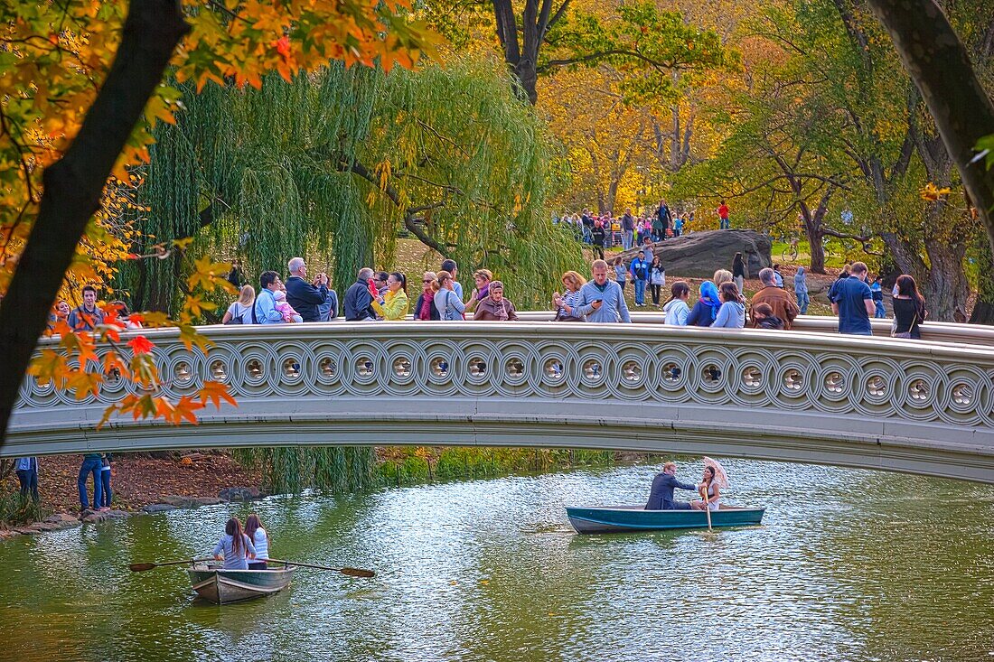 Visitors taking in the sights from the Bow Bridge in Central Park, New York, USA